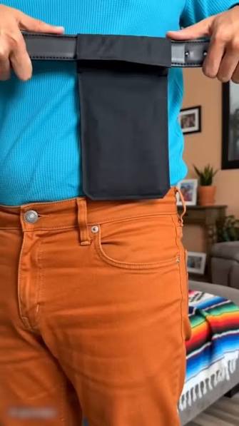 Hidden money belt pouch threaded onto a belt, shown close up