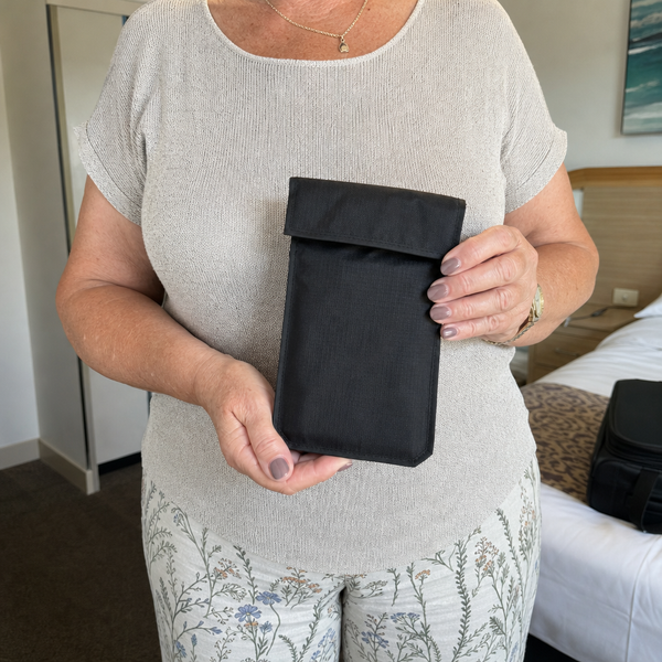 Hand holding the black hidden travel money belt pouch